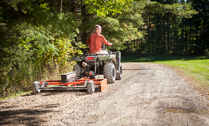 Power Grader being used to fix potholes in a driveway