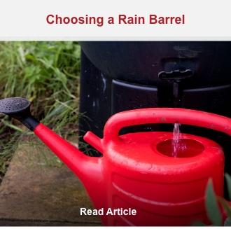 Filling a red watering can from a rain barrel