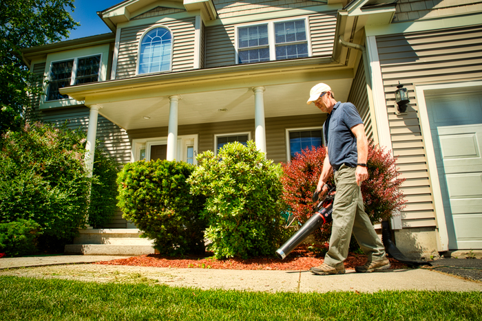 male using hand held leaf blower