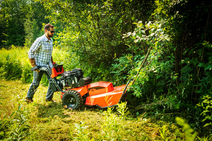 male mowing with DR brush mower