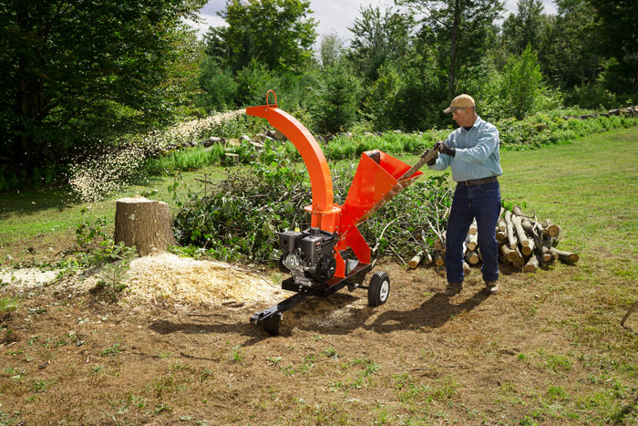 male using wood chipper