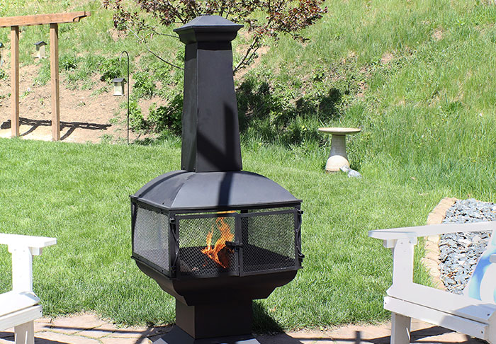 A chimnea stands on a stone patio.