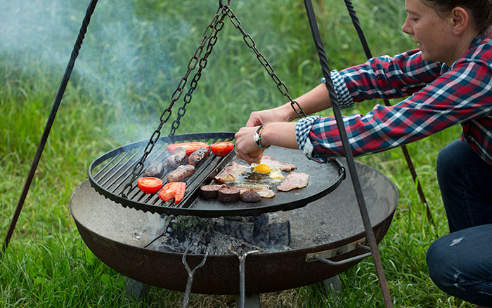 Cooking on a firepit grill outdoors.