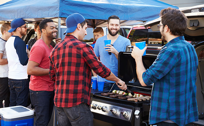 Sports fans grilling at a tailgate.