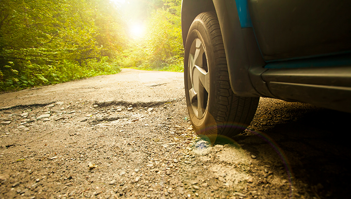 Car driving over potholes