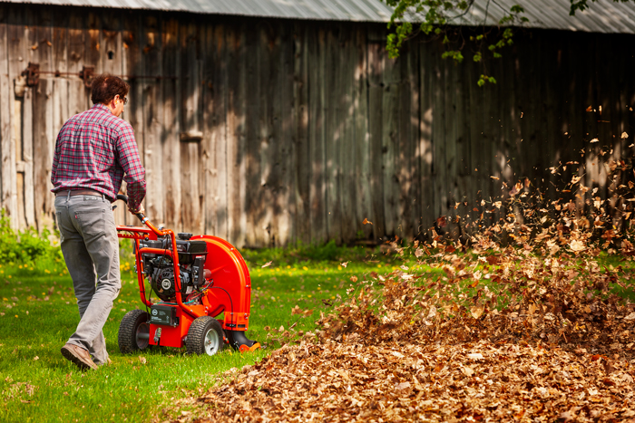 male using walk behind blower