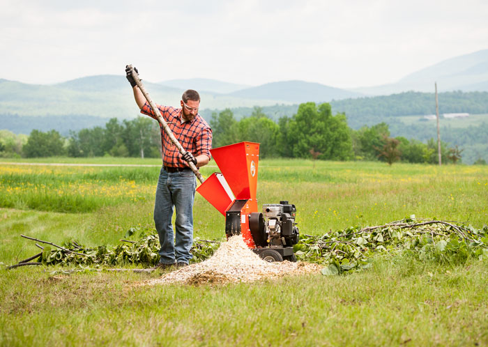 male using chipper shredder in field