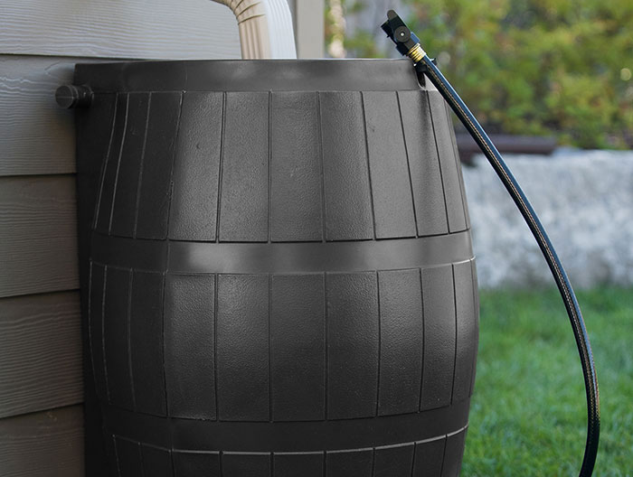 A drain pipe directing into a rain barrel