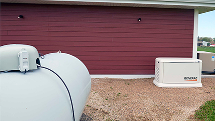 Generac generator shown with LP tank and LTE Fuel Tank Monitor attached to tank.