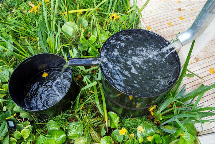 Water draining into smaller buckets on a lawn