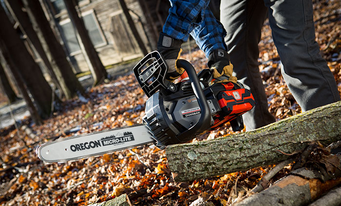A cordless electric chainsaw in use.