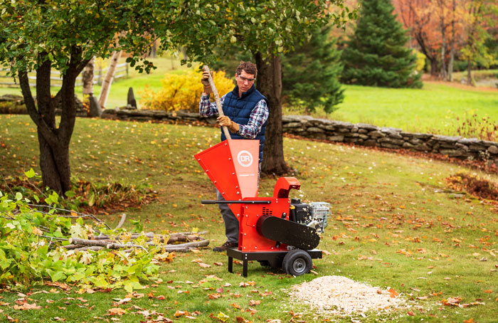 male using chipper shredder in field