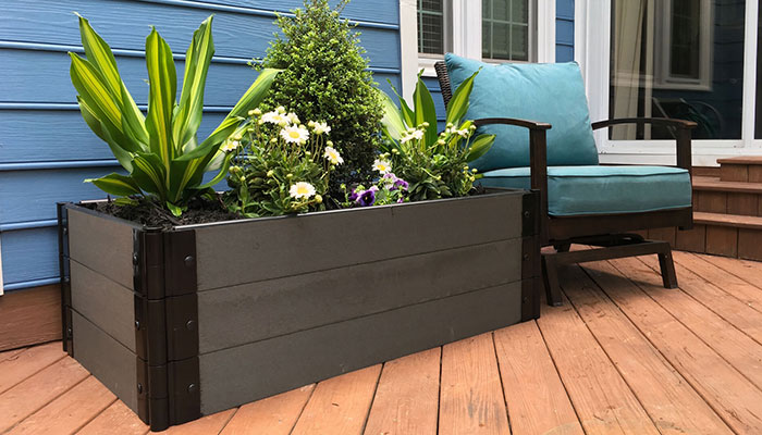 A tall planter sits on a porch