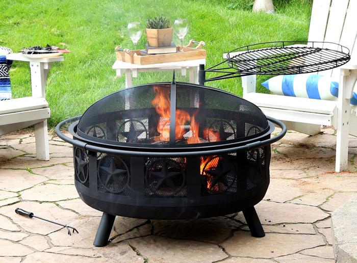 a fire pit sits on a stone patio